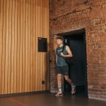 A sporty man leaving a brick-walled sports hall, embodying active lifestyle and fitness.